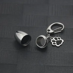 Detailed view of an open stainless steel mini cremation urn keychain with paw print charm