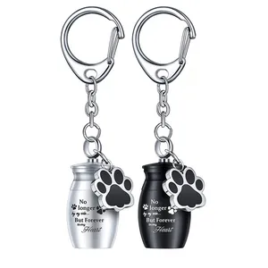 Llaveros de urna funeraria para mascotas en plata y negro con dije de huella de perro
