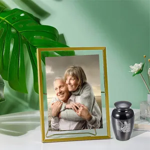 Small black memorial cremation urn with eagle engraving and elegant gold photo frame
