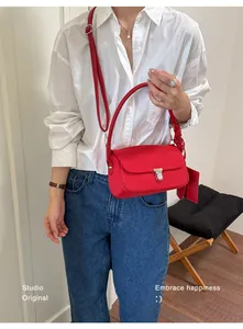 Model wearing a red nylon crossbody bag with silver buckle and attached card pouch
