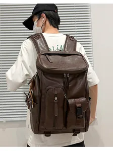 Detailed view of a vintage brown leather backpack worn by a model in a minimal indoor setting