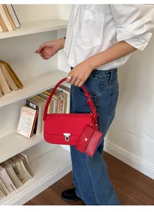 Stylish red nylon commuter underarm bag featuring a metal lock and matching small card pouch