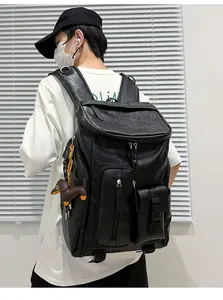 Rear view of a man wearing a stylish large black vintage backpack with a dog charm