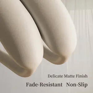 Close-up van een matte kledinghanger met brede schouder en antisliptextuur in beige.