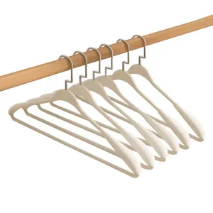 Minimalistische crème matte hangers met brede schouders aan een natuurlijke houten roede