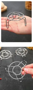 Detailed view of a mini stainless steel steamer rack held in hand for scale comparison