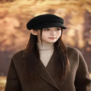 Close-up of a stylish black wool baker boy hat worn for a cozy autumn fashion look.