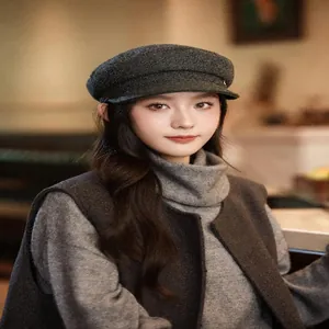 A detailed view showing a stylish brown wool newsboy cap worn by an Asian female model