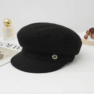 Classic black wool newsboy hat featuring a small gold metallic logo detail.