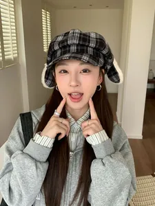 Cute plaid newsboy cap with plush earflaps worn by an Asian model in a cozy indoor setting