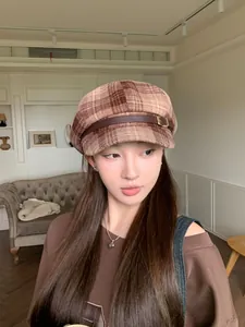 Close-up of a stylish plaid newsboy cap with a faux leather strap for women's winter