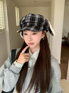 Asian model wearing a black plaid octagonal hat with plush rabbit ears for winter