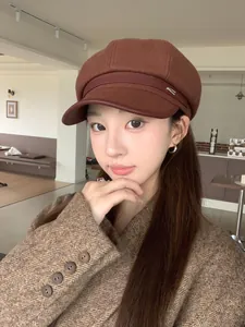 Asian model wearing a vintage brown wool newsboy hat with stylish leather brim details