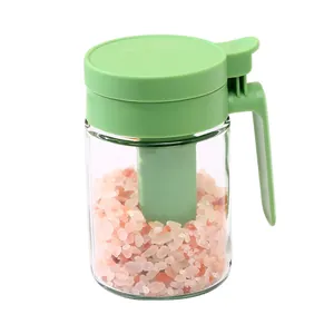 Sealed glass seasoning jar with integrated spoon and green lid for spice storage