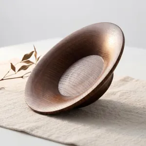 Piatto tondo minimalista in legno di giuggiolo con venature naturali su fondo di lino