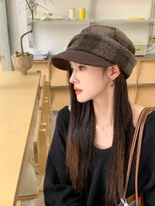 Profile view of a stylish wool plaid newsboy hat for women worn in a cozy cafe.