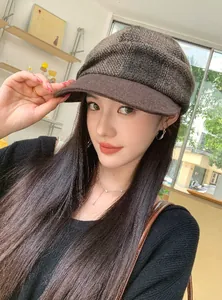 Stylish Asian model wearing a retro brown plaid wool newsboy hat for autumn and winter style