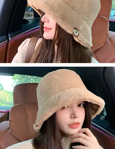 Asian woman wearing a thick camel plush bucket hat inside a car for winter warmth