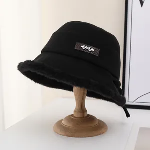 Detailed shot of a black wool bucket hat with soft faux fur trim and metal buckle