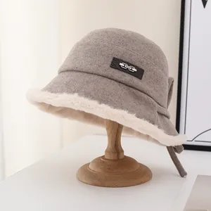 Detail of winter wool bucket hat with soft fur trim and decorative metal brand tag