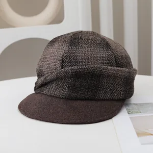 Detailed view of a vintage wool plaid newsboy cap in brown for autumn and winter style