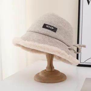 Elegant beige wool bucket hat with soft plush trim and a decorative metal chain detail