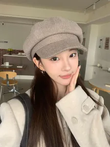 Close-up of a retro British style solid color newsboy cap for women in a cafe setting