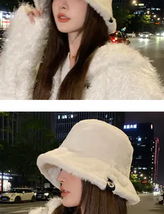 Detail view of a white plush bucket hat worn by a model in a night city setting