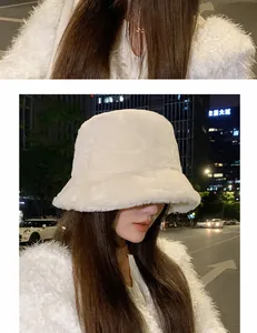 Detail shot of a woman wearing a white plush bucket hat in a nighttime city setting