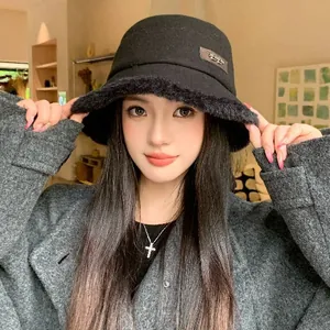Elegant black wool bucket hat with fuzzy brim for women, warm winter fashion accessory.