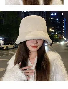 White fuzzy plush bucket hat for women in a street style winter setting.