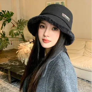 Stylish black wool bucket hat with thick furry brim for warm winter fashion and face slimming
