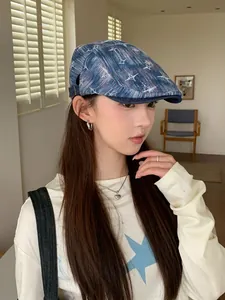 Casquette plate en jean délavé avec un motif d'étoiles blanches portée par un mannequin