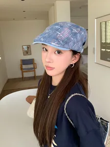 Vue détaillée d'une casquette plate en denim bleu délavé avec motifs d'étoiles.