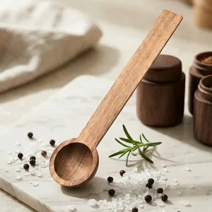Handcrafted mini acacia wood seasoning spoon for spices and honey on marble surface.