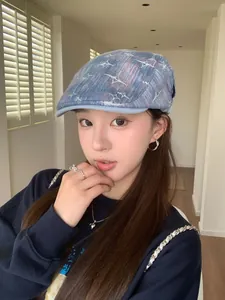 Gros plan d'une casquette plate en jean délavé bleu avec broderie étoile blanche à quatre branches