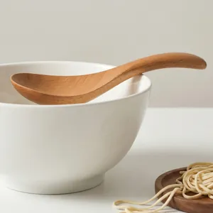 Handcrafted Japanese style wooden soup spoon for ramen and noodles in a ceramic bowl