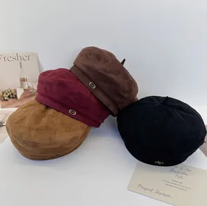 Collection of retro suede berets in various colors showing soft texture and metal detail