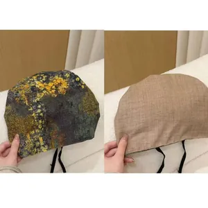 Vue détaillée du motif vintage et du tissu beige uni du bonnet souple de style rétro.