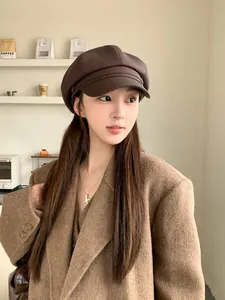 Detailansicht einer stilvollen braunen Newsboy-Mütze aus Kunstleder an einem Modell