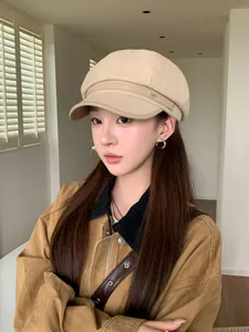 Model wearing a beige wool octagonal newsboy hat for autumn and winter fashion style.