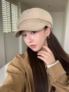 Asian model wearing a retro beige wool newsboy cap with leather brim for autumn style