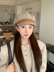 Detailed view of an Asian model wearing a stylish beige newsboy cap in a cafe