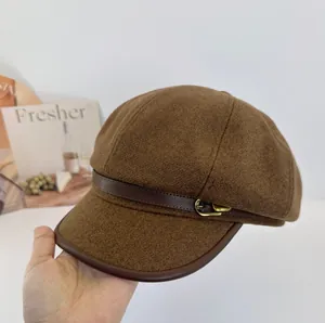 Nahaufnahme einer braunen Newsboy-Mütze aus Wolle mit Lederbesatz und Schnalle