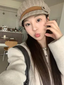 Close-up of stylish checkered tweed newsboy hat for women with brown decorative band