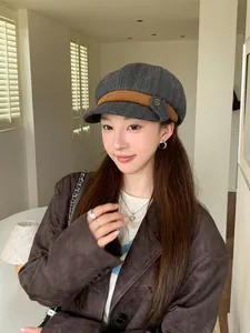 Fashionable grey patterned newsboy hat for women styled by a model in a chic indoor setting