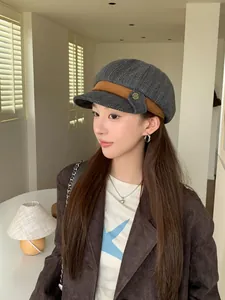 Stylish grey tweed newsboy hat with brown corduroy trim worn by a female model