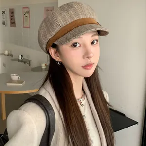 Stylish vintage herringbone newsboy hat for women worn by a model in a cozy cafe setting