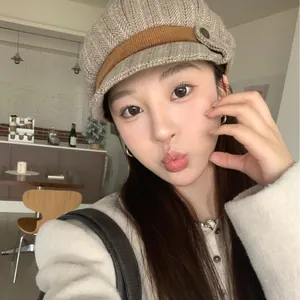 Classic women's newsboy cap featuring a vintage herringbone wool pattern in beige.