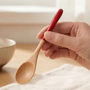 Small wooden spoon with red handle perfect for coffee stirring and serving honey in the kitchen.
